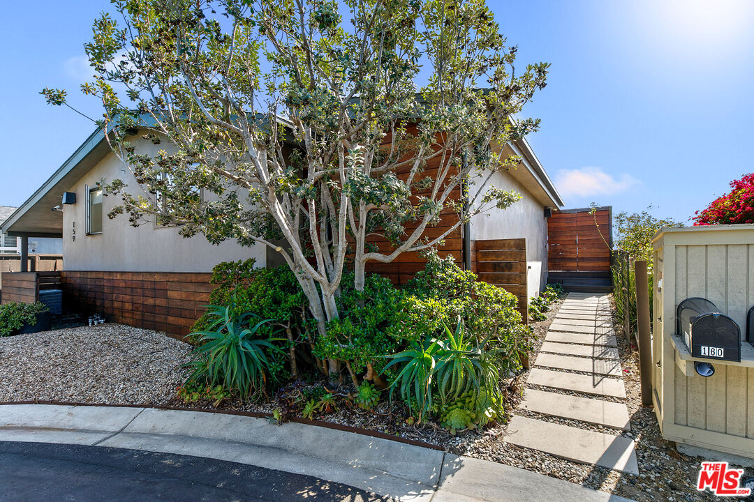 29500 Heathercliff Road, Unit 159 Malibu, CA 90265 - Photo 31 of 37 a yellow house with a tree in front of it