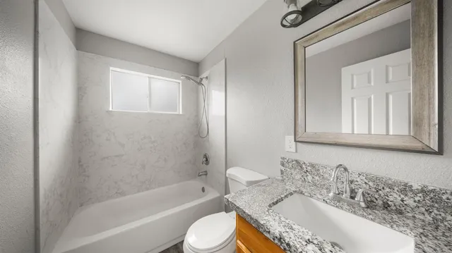 a bedroom with a large bed a chandelier and a window