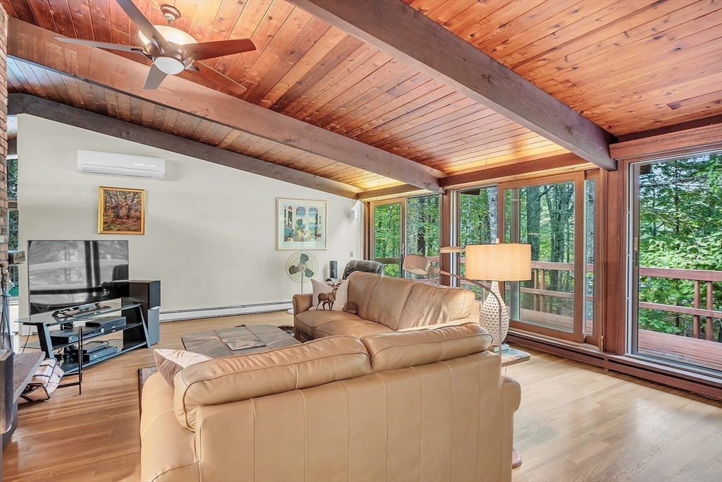 191 Heald Road Carlisle, MA 01741 - Photo 12 of 32 a living room with furniture a flat screen tv and a floor to ceiling window