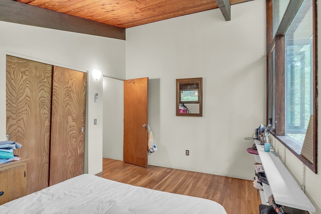 191 Heald Road Carlisle, MA 01741 - Photo 19 of 32 a bedroom with a bed and a flat screen tv