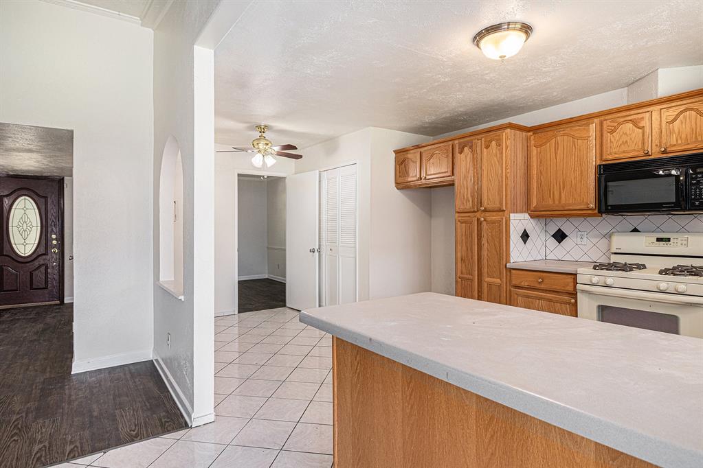 1814 Addington Drive Carrollton, TX 75007 - Photo 10 of 24 Kitchen featuring light hardwood / wood-style flooring, ceiling fan, backsplash, and white gas range oven