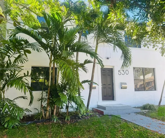 a front view of a house with a tree