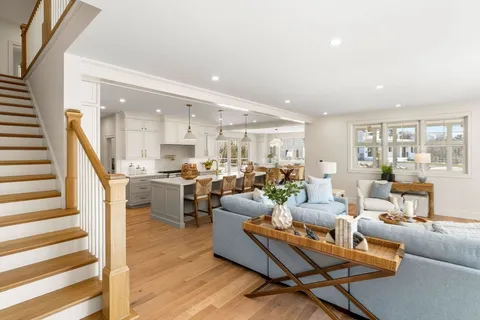 a living room with furniture kitchen view and a large window