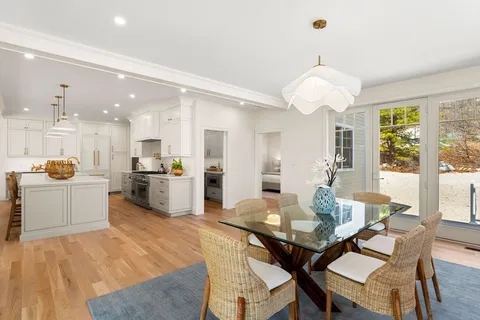 a view of a dining room with furniture large windows and wooden floor