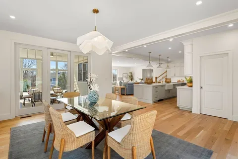 a dining room with wooden floor and chandelier