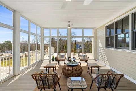 a view of a dining room with furniture large windows and wooden floor