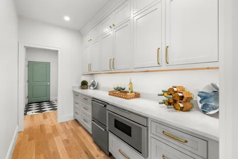 a kitchen with stainless steel appliances a sink dishwasher and cabinets with wooden floor