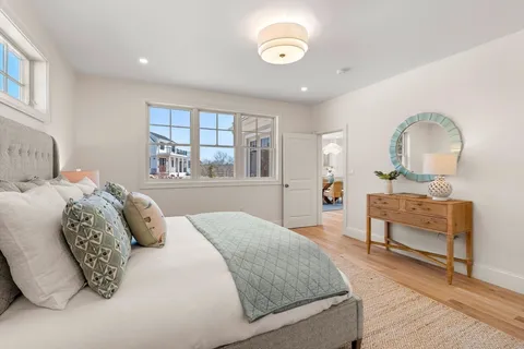 a bedroom with a balcony a bed and a dresser with mirror