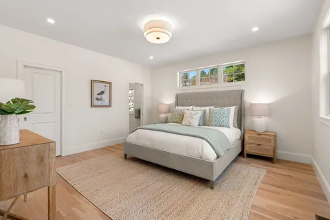 a bedroom with a large bed and a potted plant