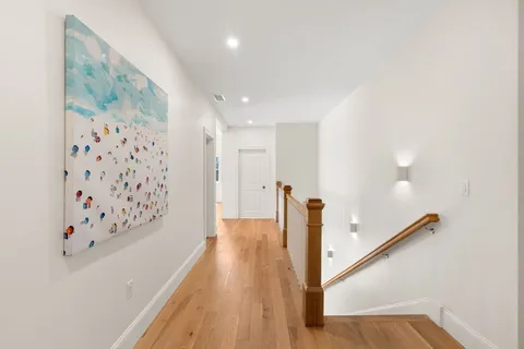 a view of a hallway with wooden floor and entryway