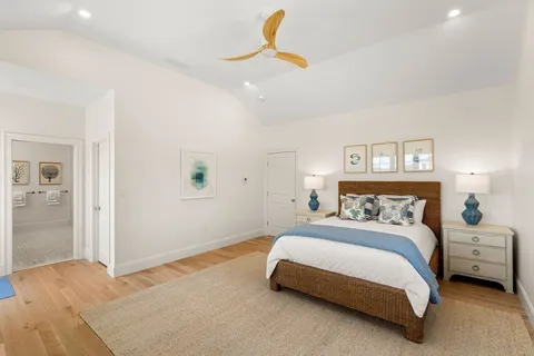 a bedroom with a bed a lamp on desk and a window