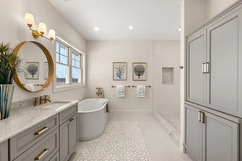 a bathroom with a double vanity sink mirror and bathtub