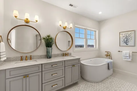 a bathroom with a granite countertop double vanity sink and a mirror