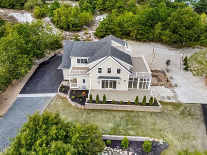 an aerial view of a house with a garden and lake view