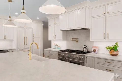 a kitchen with stainless steel appliances granite countertop a sink a stove and cabinets