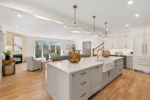 a kitchen with counter top space sink stove and wooden floor