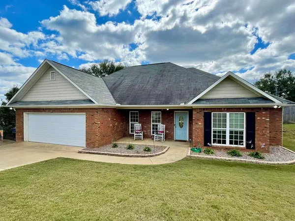 a front view of a house with swimming pool and furniture