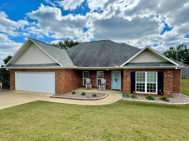 a front view of a house with swimming pool and furniture