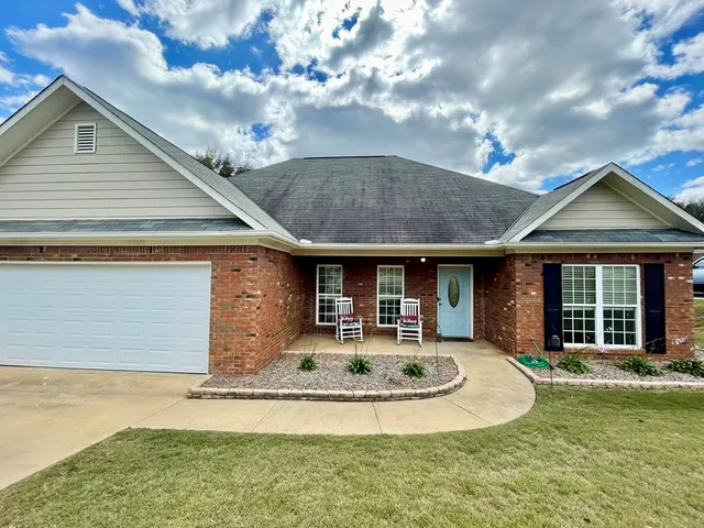 a front view of a house with a yard garage and outdoor seating