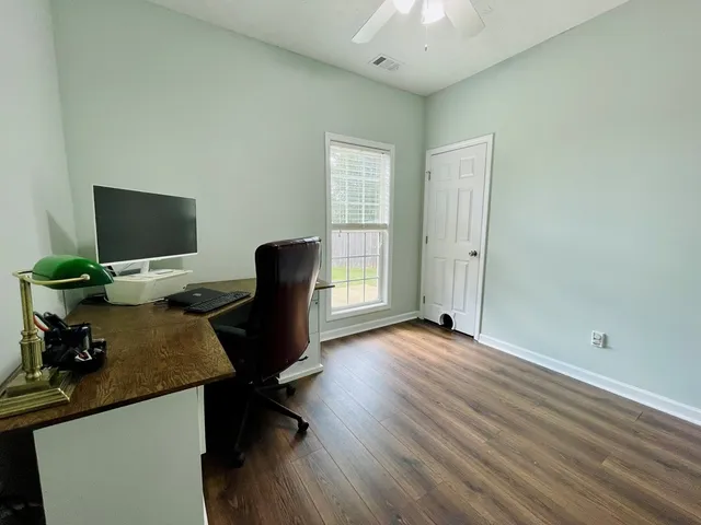 a view of a workspace with furniture and a window