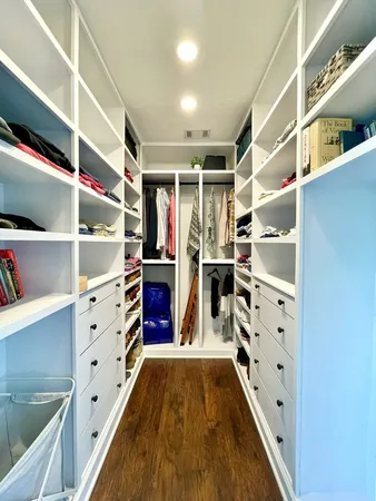 a view of walk in closet with clothes and shoes