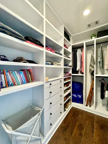 a view of walk in closet with clothes and shoes