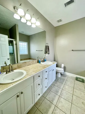 a spacious bathroom with a double vanity sink and a mirror