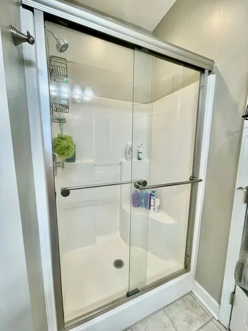 a bathroom with a glass shower door and mirror
