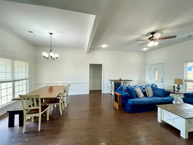 a living room with furniture dining table and a chandelier