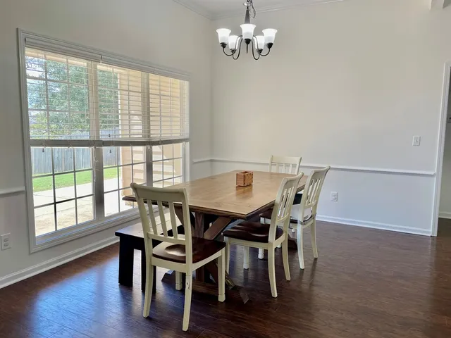 a view of a dining room with furniture a chandelier and wooden floor
