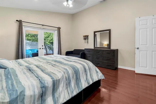 a bedroom with bed and wooden floor