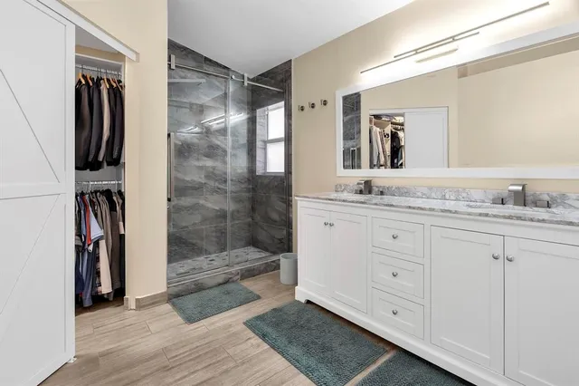 a bathroom with a granite countertop sink and a mirror