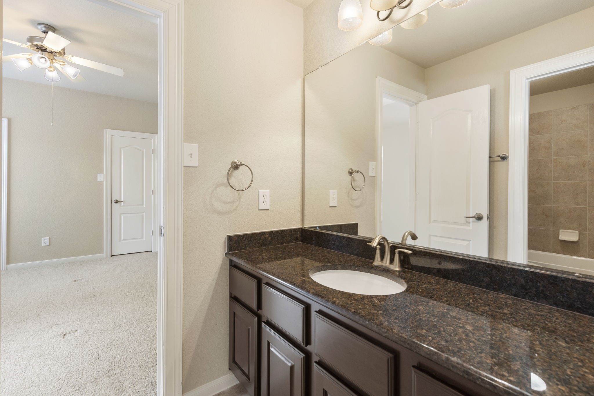 19222 Senterra Lakes Boulevard Spring, TX 77379 - Photo 26 of 45 This upstairs bathroom connects two secondary bedrooms, featuring a long vanity with a dark countertop and ample under-sink storage.
