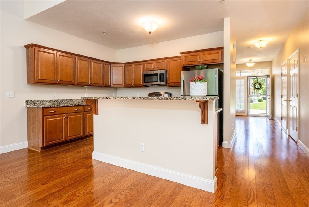 45 Grey Hawk Drive, Unit 45 Mashpee, MA 02649 - Photo 6 of 21 a kitchen with a refrigerator a stove top oven a sink dishwasher and wooden floor