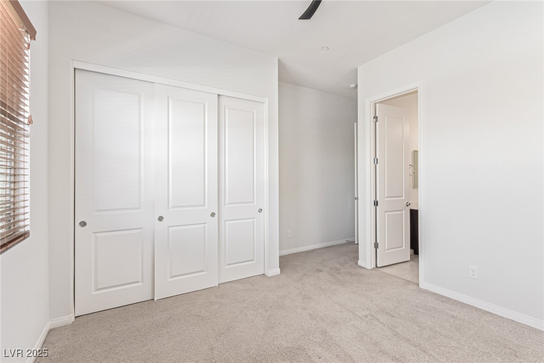 298 Nine Mile Creek Drive Las Vegas, NV 89138 - Photo 22 of 30 Unfurnished bedroom featuring light colored carpet, ceiling fan, and a closet