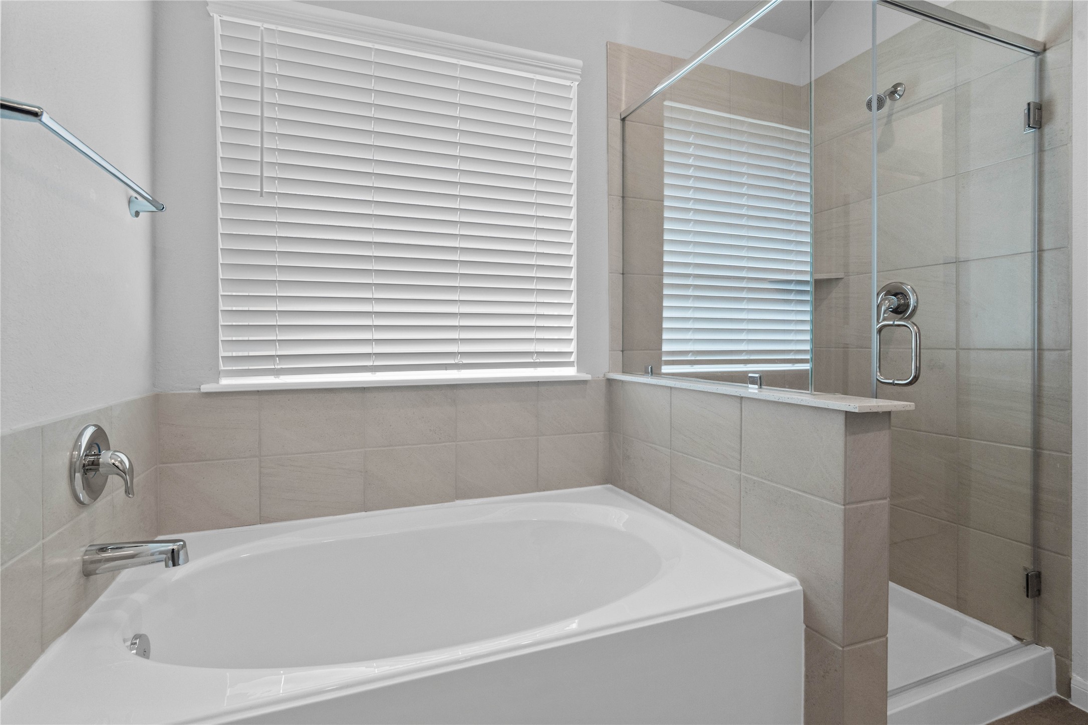 19645 Montgomery Rdg Way Montgomery, TX 77316 - Photo 30 of 41 Indulge in relaxation within this spa-inspired primary bathroom, offering both a quick shower and a tranquil soaking experience. The walk-in shower is glass enclosed with modern tile walls and sleek finishes.
