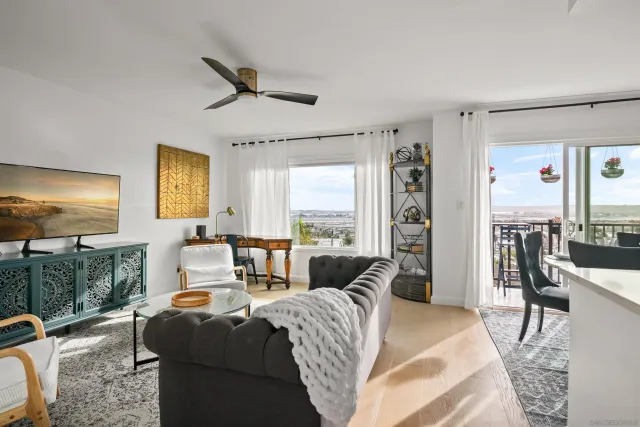 a living room with furniture a flat screen tv and a floor to ceiling window