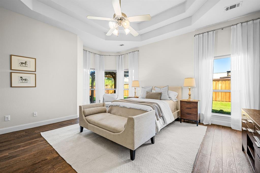 8 Center Court Heath, TX 75032 - Photo 19 of 34 a spacious bedroom with a bed and a chandelier