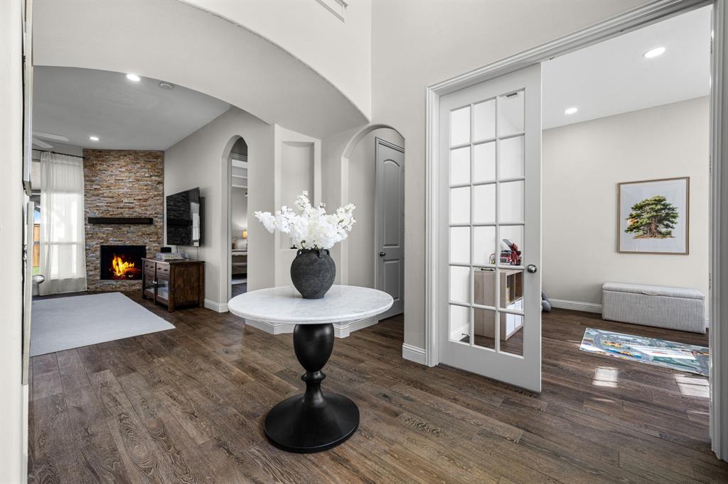 8 Center Court Heath, TX 75032 - Photo 9 of 34 a living room with furniture a fireplace and a chandelier