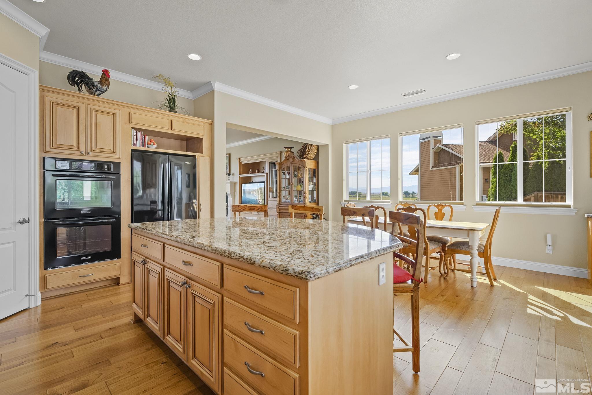 2892 Promontory Drive Genoa, NV 89411 - Photo 13 of 40 a kitchen with stainless steel appliances granite countertop sink stove and wooden cabinets