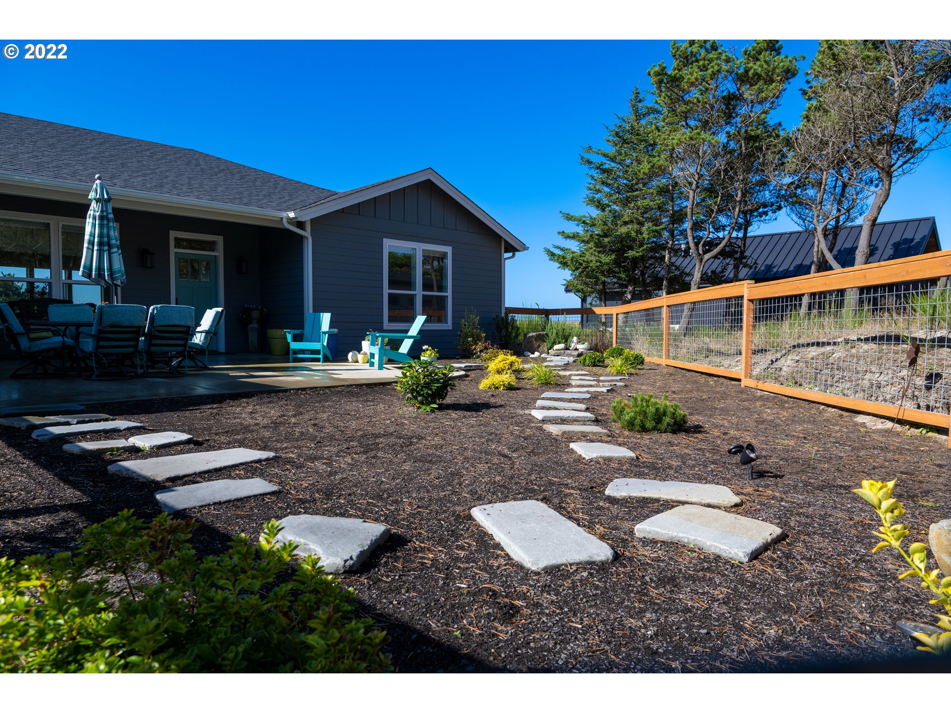 89442 Ocean Drive Warrenton, OR 97146 - Photo 18 of 31 a backyard of a house with wooden floor barbeque oven and outdoor seating