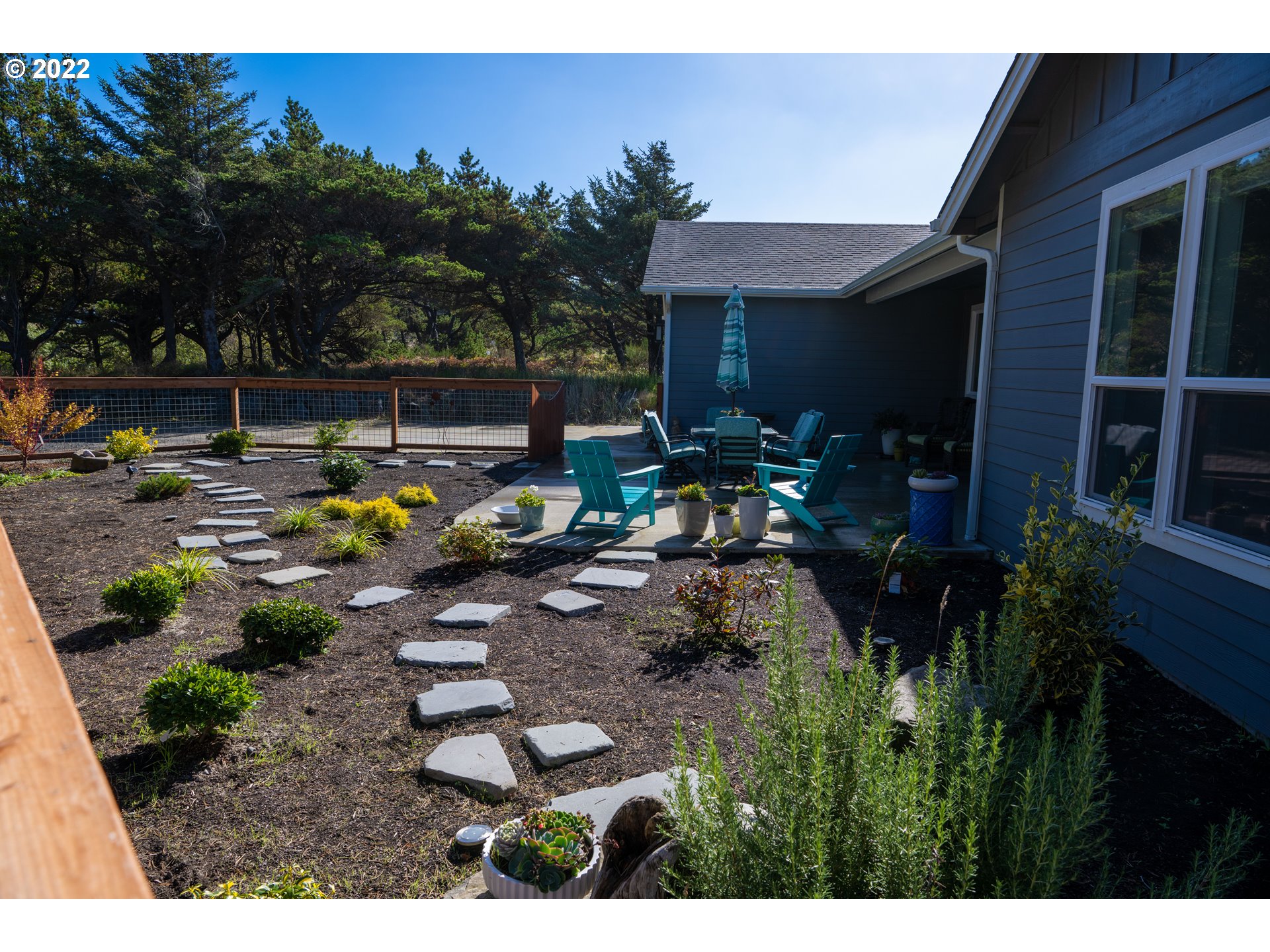 89442 Ocean Drive Warrenton, OR 97146 - Photo 20 of 31 a view of a backyard with plants and a patio