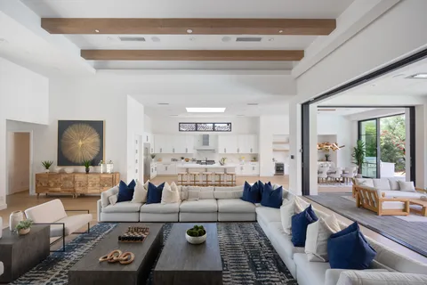 a living room with furniture a flat screen tv and a large window