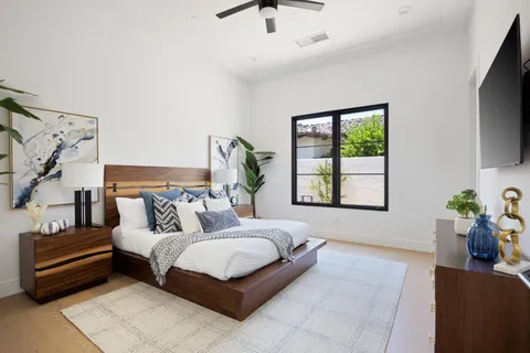 a bedroom with a bed wooden floor and window