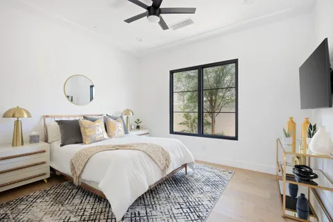 a bedroom with a bed and a flat tv screen on wall