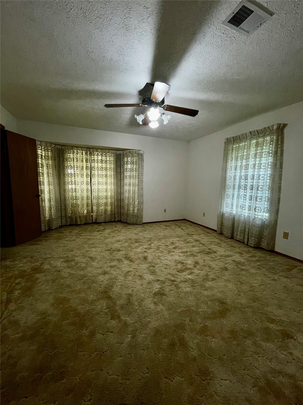 10074 Overbrook Drive Conroe, TX 77304 - Photo 14 of 22 a view of an empty room with windows and chandelier fan