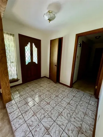 a view of a hallway with wooden floor and windows