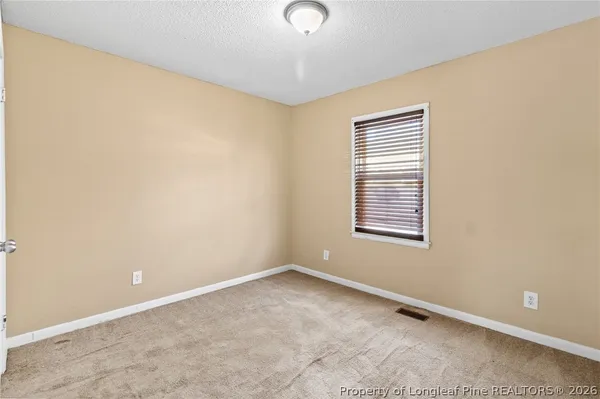a view of a room with a chandelier fan and wooden floor