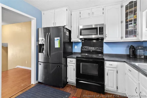 a kitchen with granite countertop white cabinets and sink