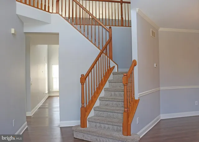 a view of staircase with wooden floor and white walls